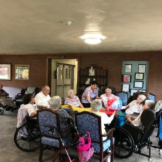 A group of elderly people gathered together in a nursing home setting.