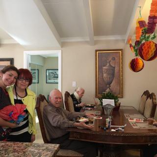 A group of people gathered in a cozy dining room with vibrant decorations.