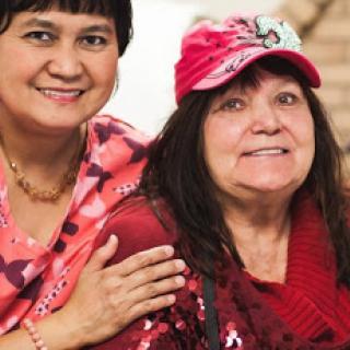 Two women pose together, smiling and enjoying each other's company.