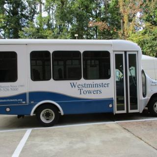 A Westminster Towers shuttle bus parked outdoors.