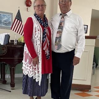 A joyful couple dressed in patriotic attire, celebrating in a festive environment.