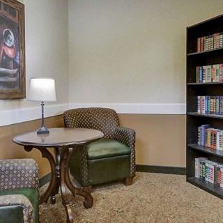 Cozy library corner with armchairs and a bookshelf.