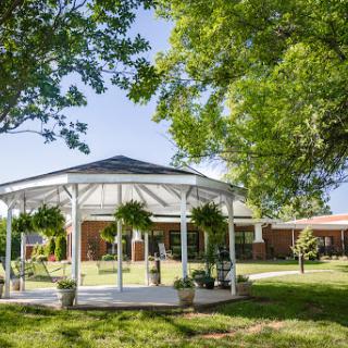 A beautifully designed gazebo surrounded by lush greenery, perfect for outdoor gatherings.