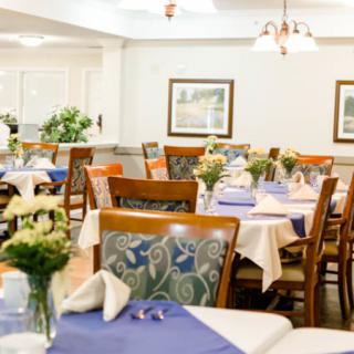 A cozy dining room with neatly arranged tables and floral decorations.