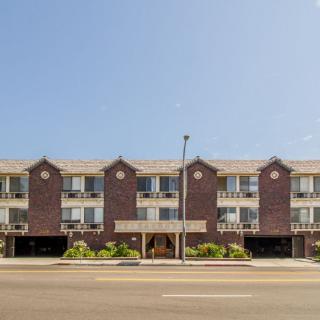 A three-story residential apartment building with brick exterior, seen from the street.