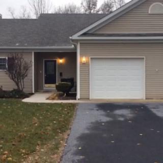 A suburban house with an attached garage and a paved driveway.