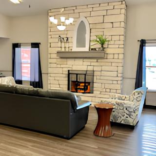 A cozy living room featuring a brick fireplace and comfortable seating arrangements.