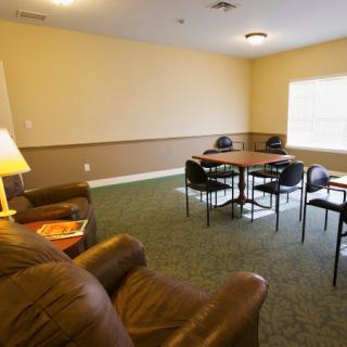 A cozy meeting area with a sofa and table, featuring comfortable seating and warm lighting.