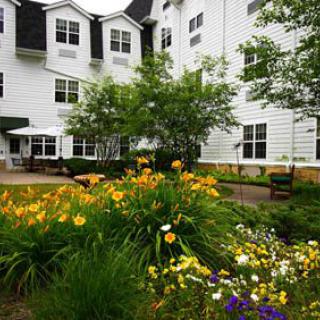 A beautifully landscaped garden in front of a white multi-story building.