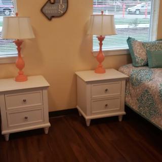 A cozy bedroom with matching nightstands and vibrant lamps.