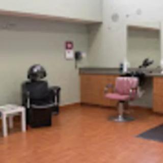 A salon interior featuring a hair styling chair and mirror setup.