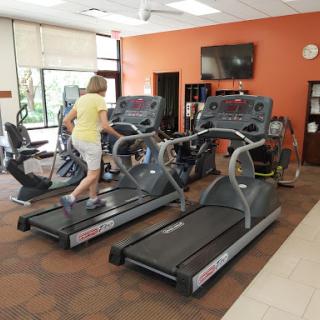 A person exercising on a treadmill in a gym setting.