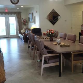 A dining room with a long table and chairs, adorned with decorative flowers.