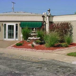 A well-maintained building entrance surrounded by vibrant landscaping and greenery.
