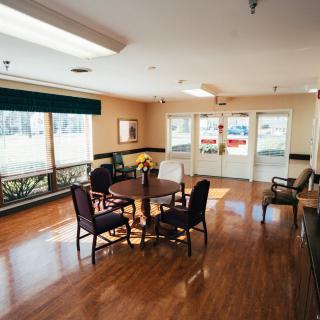 A bright and spacious room with wooden floors, large windows, and a seating area.