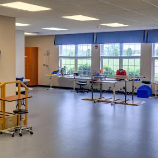 A spacious and well-lit therapy room equipped for rehabilitation services.