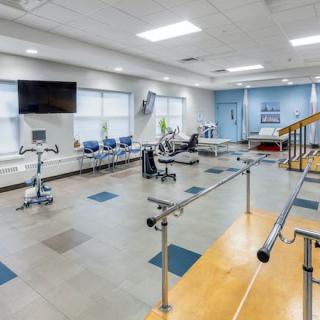 A well-equipped physical therapy and rehabilitation room with various exercise equipment.