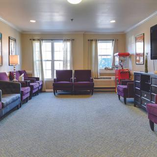 A cozy living room with multiple seating options, a TV, and a popcorn machine.