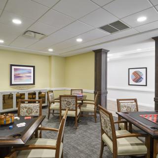 A cozy dining area with several tables and chairs, decorated with artwork on the walls.