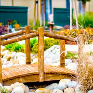 A charming wooden bridge surrounded by decorative rocks in a serene garden setting.