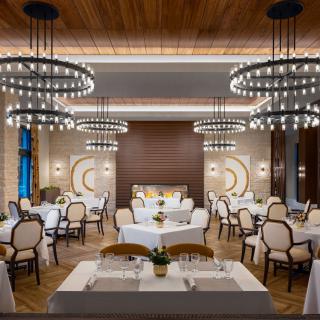 An elegantly designed restaurant interior featuring chandeliers and neatly arranged tables.