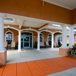 Elegant building entrance with white columns and a covered walkway.