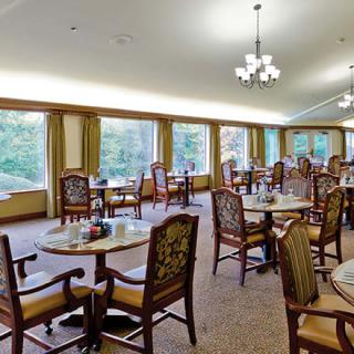 A spacious dining room with elegant furnishings and large windows.