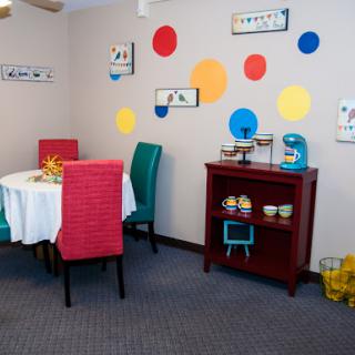 A vibrant dining area featuring colorful chairs and playful wall decor.