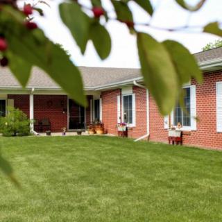 A brick house with a well-maintained lawn and front yard.