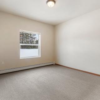 A bright, empty room with a window allowing natural light to fill the space.