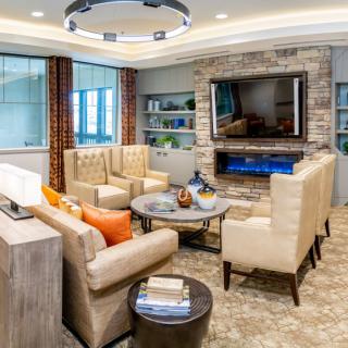 Modern living room with a contemporary seating area, TV, and fireplace.
