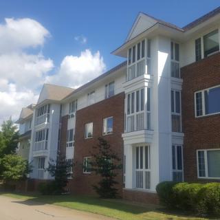 A modern three-story apartment building with a brick facade.
