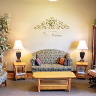 A cozy living room with a patterned sofa, wooden coffee table, and matching side tables with lamps.