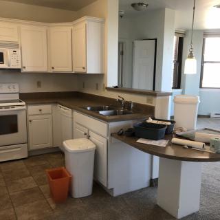 A modern kitchen interior featuring white cabinets and standard appliances.