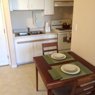 A small apartment kitchen with a dining table set for two.