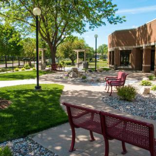 A peaceful park area with benches, trees, and a well-maintained garden.