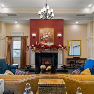 A cozy living room featuring a fireplace, chandelier, and elegant decor.