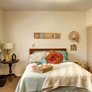 A cozy bedroom with a neatly made bed and decorative accents.