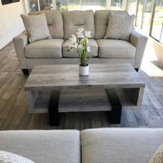 A modern living room featuring a comfortable sofa set and a stylish coffee table with a flower arrangement.