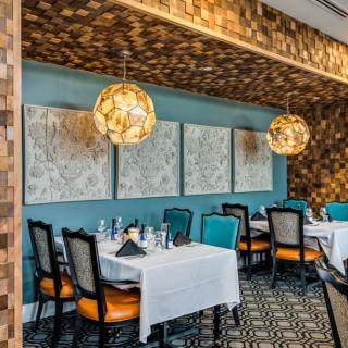 A beautifully decorated restaurant interior with neatly arranged tables, elegant chairs, and artistic lighting.