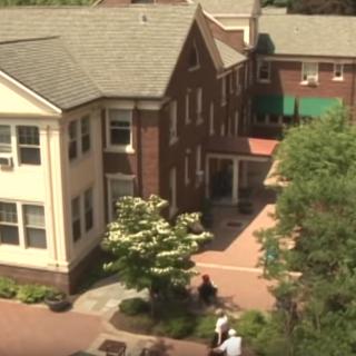 Aerial view of a brick building with trees and pathways.