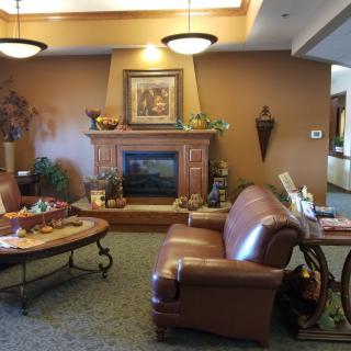A cozy living room with a fireplace, sofa, and decorative elements.