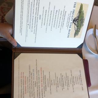 A menu open on a table in a restaurant setting, displaying food and drink options.