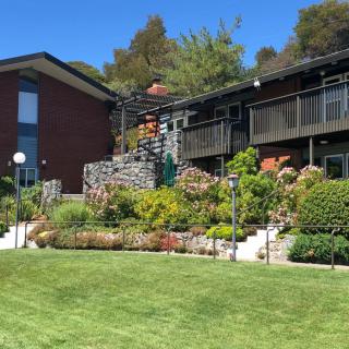 A modern house with a well-maintained garden and lawn, surrounded by lush greenery.