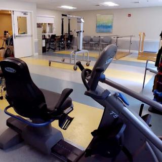 A view of a fitness area featuring exercise equipment, designed for rehabilitation and workout activities.