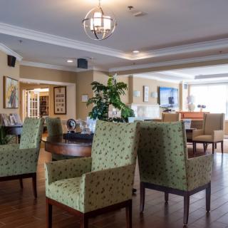 A cozy lounge area with patterned chairs, wooden flooring, and decorative elements.
