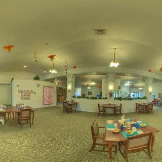 A spacious dining area with decorated tables and elegant lighting.
