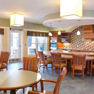 A modern kitchen and dining area with wooden furniture and stylish lighting.