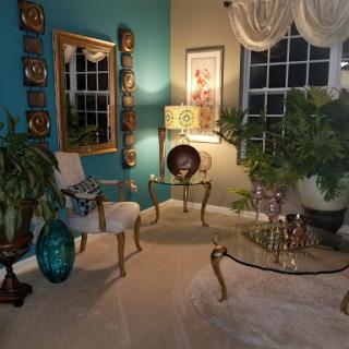 A beautifully styled living room corner featuring elegant furniture, vibrant colors, and lush plants.