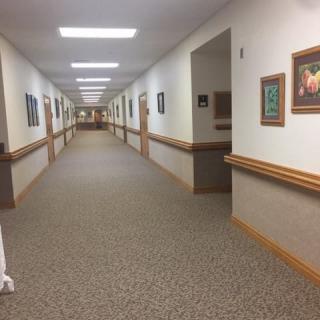 A well-lit hallway with artwork on the walls.